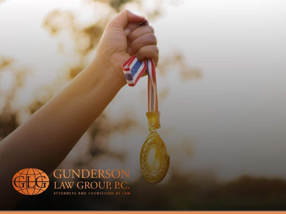 woman hands raised and holding a gold medal