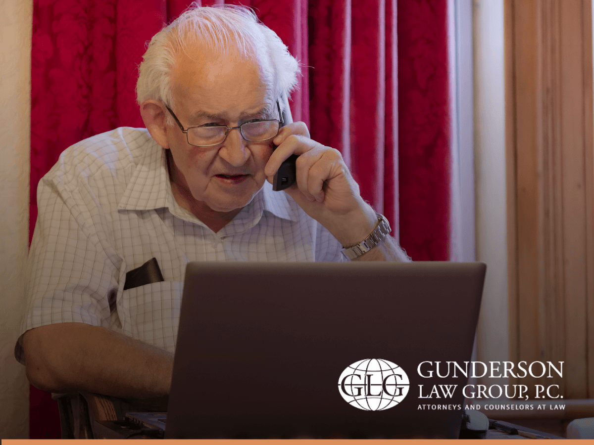 Senior man on phone at laptop, victim of estate planning scam