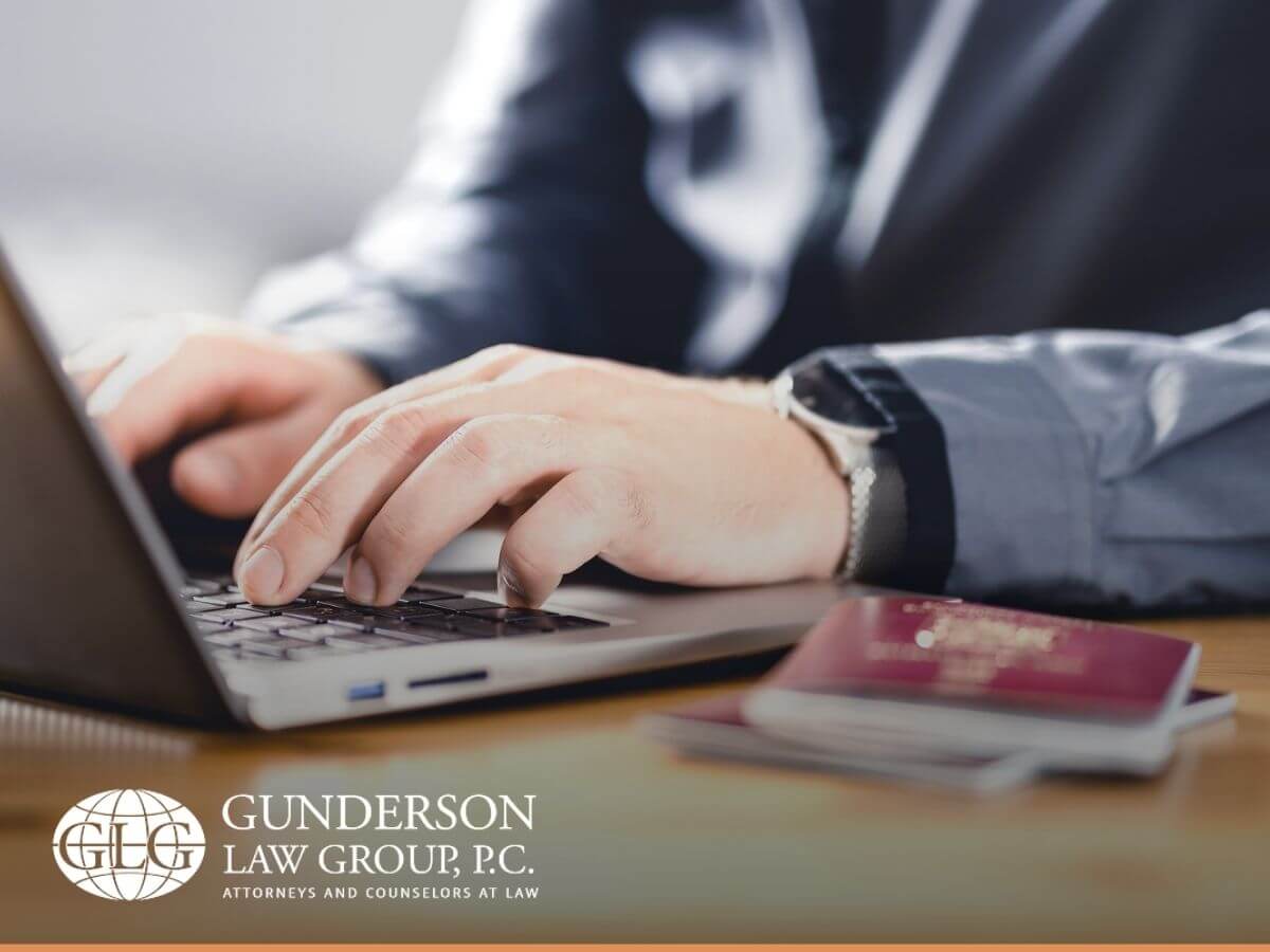 Man working on laptop with two passports at his side