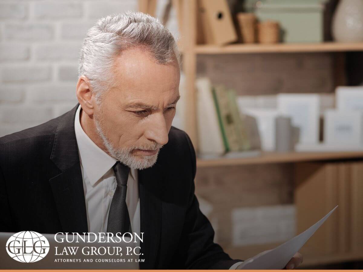 Senior man reviewing legal papers of his estranged noncitizen spouse with advices from the Gunderson Law blog